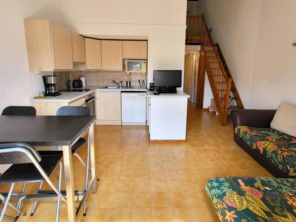 une cuisine et un salon avec une table et un canapé dans l'établissement T3 Duplex à 200 m Plages/Commerces - Parking, Wi-Fi, Piscine, Tennis - Animaux Acceptés - FR-1-316-104, à Six-Fours-les-Plages