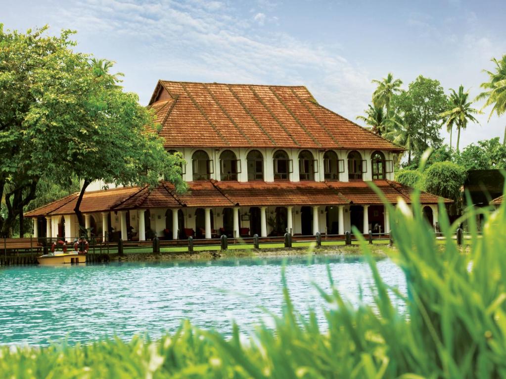 a large building with a pool of water in front of it at Taj Kumarakom Resort and Spa Kerala in Kumarakom