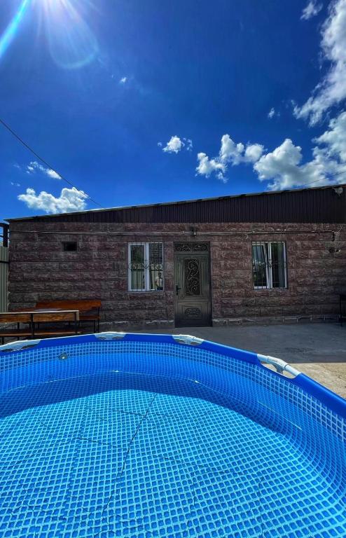 una piscina azul frente a un edificio de ladrillo en Lidiani Guest House en Gyumri