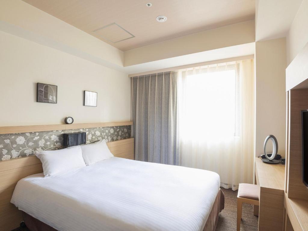 Postel nebo postele na pokoji v ubytování Hotel Keihan Yodoyabashi