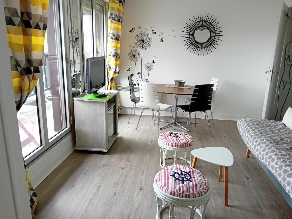 un salon avec une table et des chaises dans l'établissement Nid douillet proche de la mer et de la gare, à Houlgate