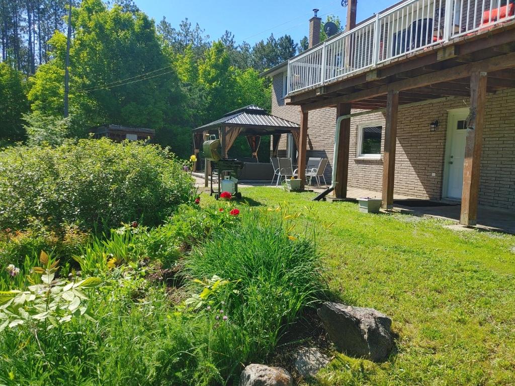 un giardino con gazebo sul lato di una casa di The Nest in the Forest Bed and Breakfast (Hot tub and Sauna) a Lakefield