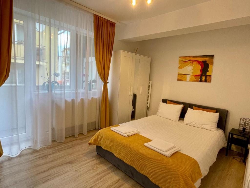 a bedroom with a bed with two towels on it at Yellow Apartment in Floreşti