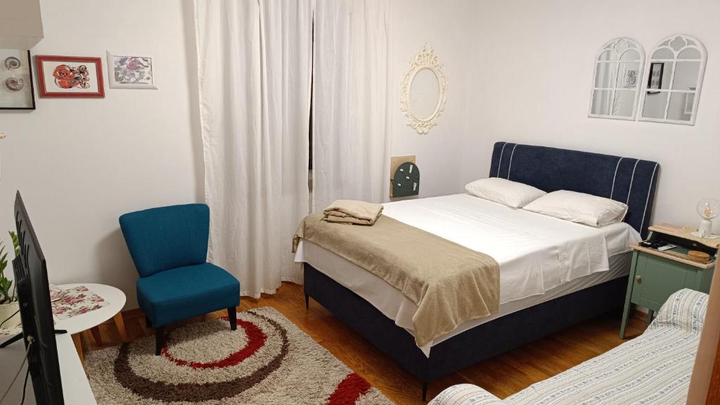 1 dormitorio con 1 cama y 1 silla azul en Apartment Split Stone House, en Split