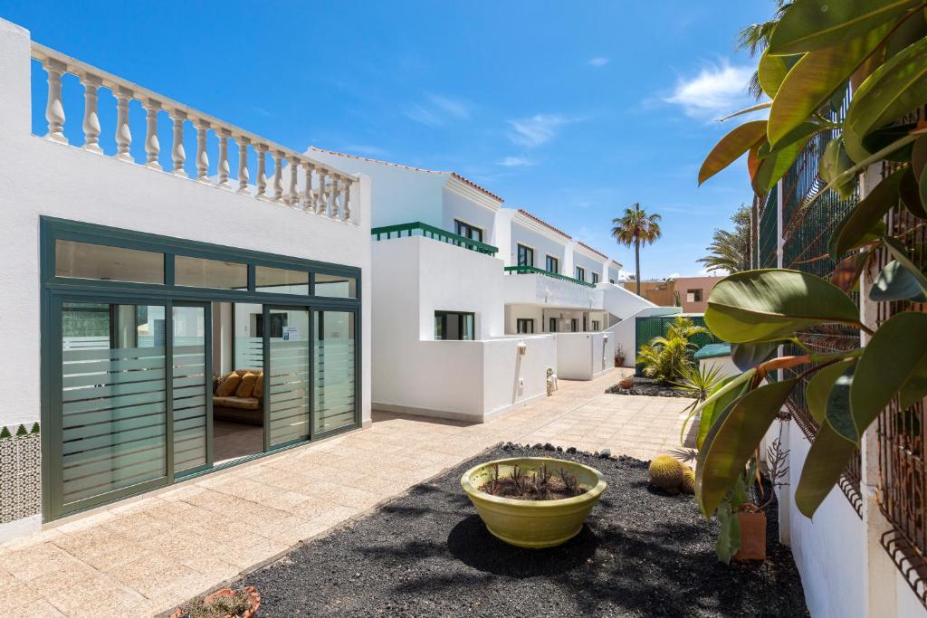 een huis met glazen deuren en een patio bij Apartamentos LIVVO Erika in Corralejo