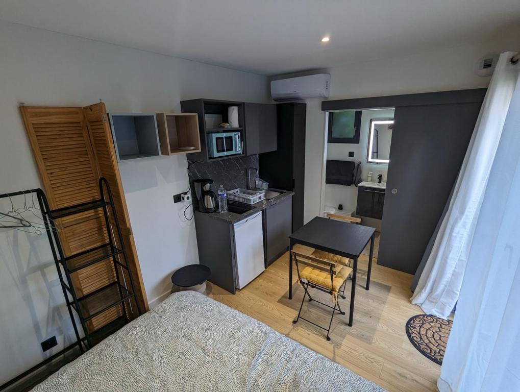 Il comprend une petite cuisine avec une table et une petite cuisine avec un bureau. dans l'établissement Les CosyHouilles Chambre Nati, à Houilles