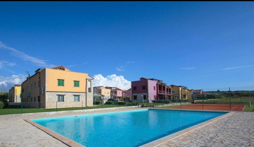 ein großer Pool vor einigen Gebäuden in der Unterkunft Jovì`s Apartment in Tar
