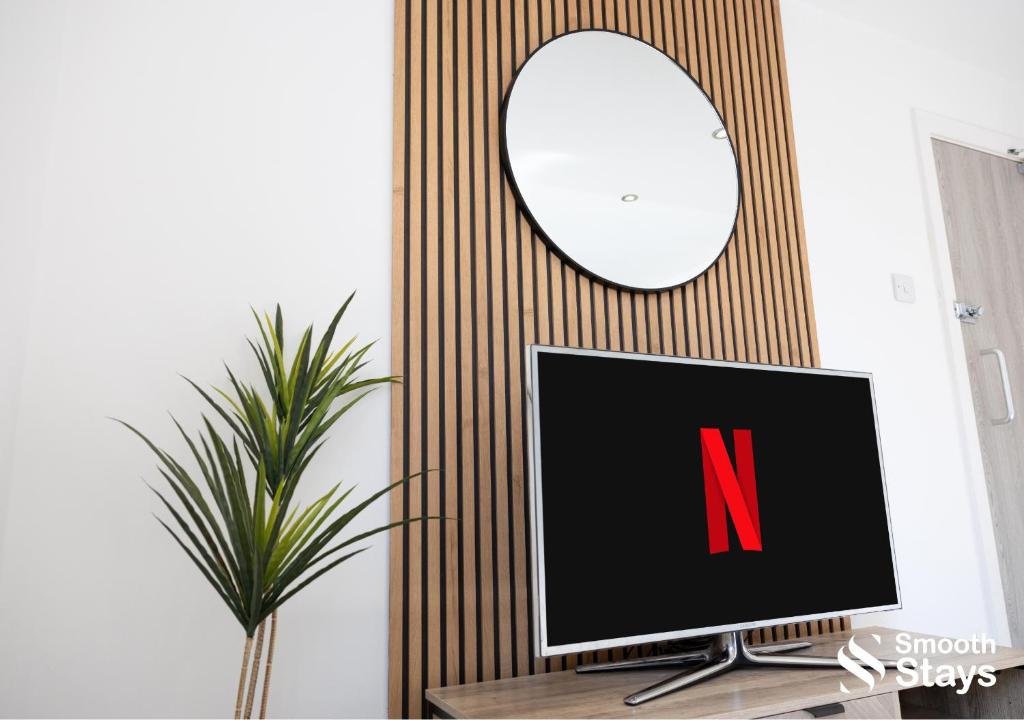 - un ordinateur installé sur un bureau avec un miroir dans l'établissement One Bedroom Apartment At Smooth Stays Short Lets & Serviced Accommodation Preston With Parking Near Train Station, à Preston