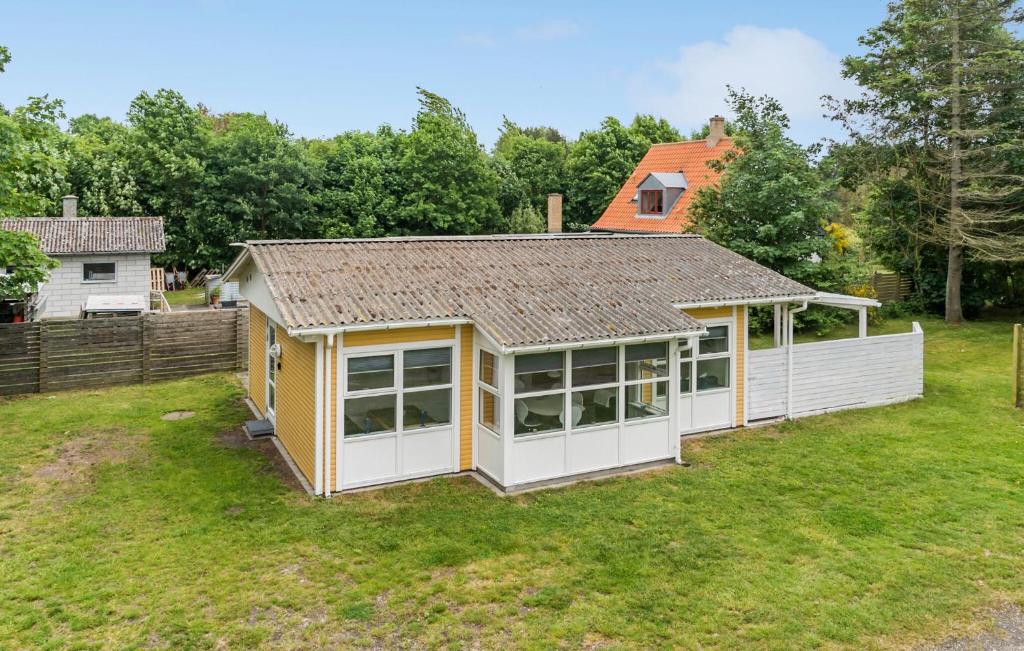 un pequeño cobertizo blanco y amarillo en un patio en 2 Bedroom Lovely Home In Sams en Onsbjerg