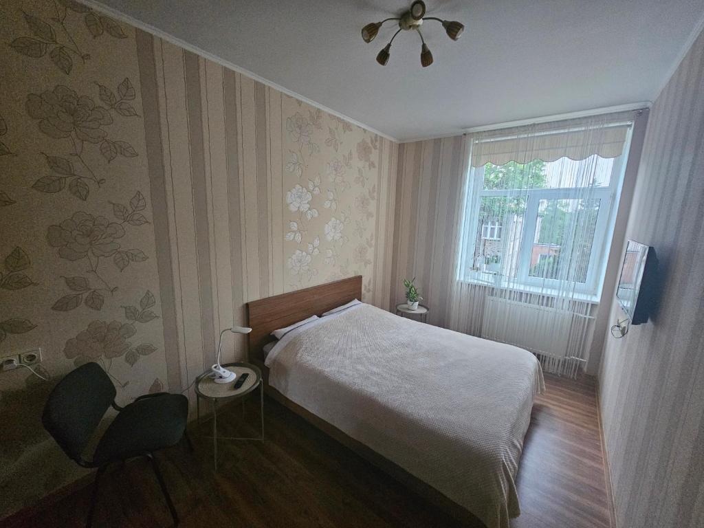 a small bedroom with a bed and a window at Liepu gatve in Klaipėda