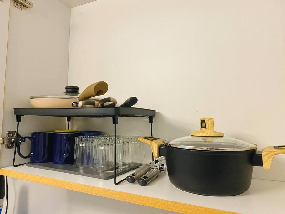a shelf with a pot and other kitchen items on it at Stylish Studio in Downtown with Remote Work Setup in Cabaguio