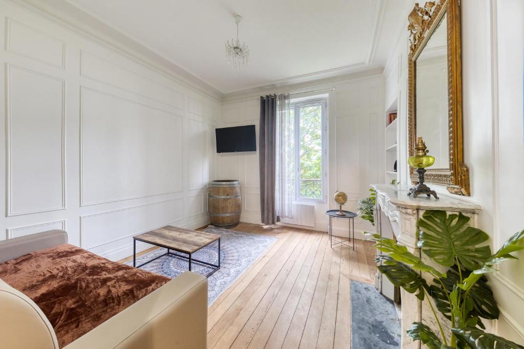 ein weißes Zimmer mit einem Bett und einem Spiegel in der Unterkunft Coup de cœur parisien à 15 mn de Paris - 45 mn Disney in Noisy-le-Sec