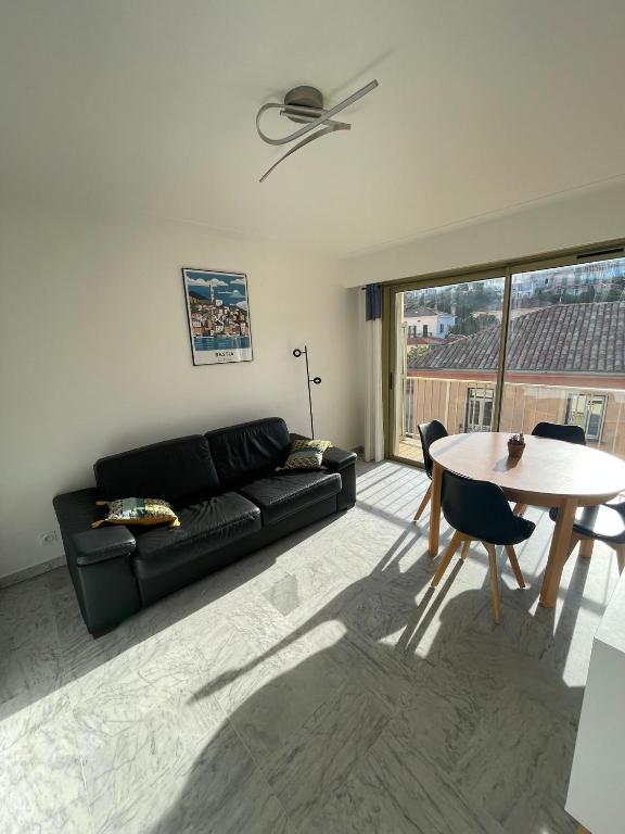 un salon avec un canapé noir et une table dans l'établissement VOLTA, à Bastia