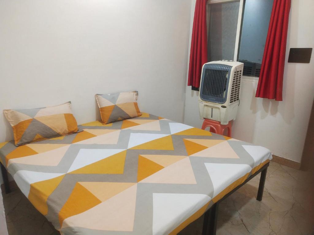 een slaapkamer met een bed, een raam en een radiator bij Maa yatri niwas (home stay) in Ujjain