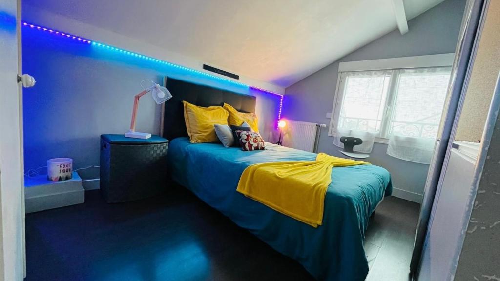 a bedroom with a bed with a blue and yellow blanket at Charmante maison au Nord de Paris piscine chauffée in Argenteuil