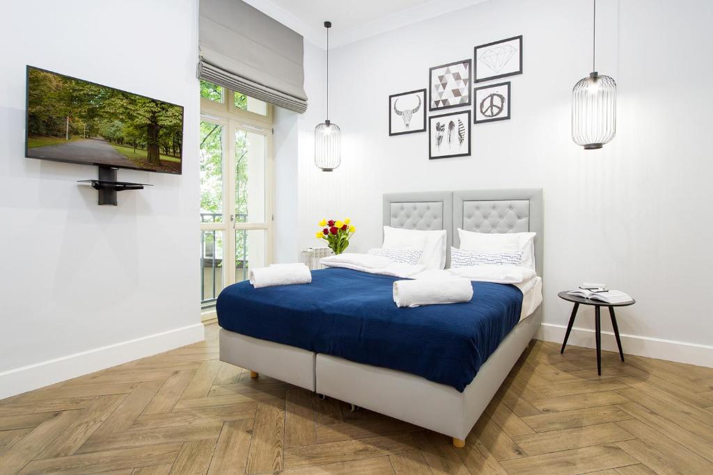 a bedroom with a bed with a blue blanket at Old Town Residence at Topolowa in Krakow