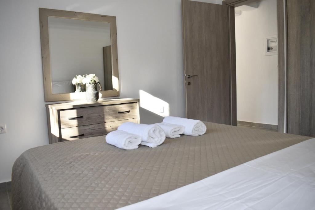 a bedroom with a bed with towels on it at Irina's Apartment 2 in Psakoudia