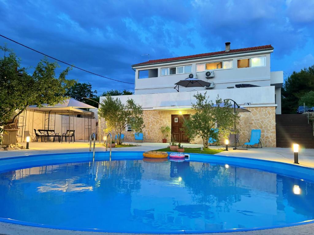 a swimming pool in front of a house at Apartments Villa Mihaela in Banj