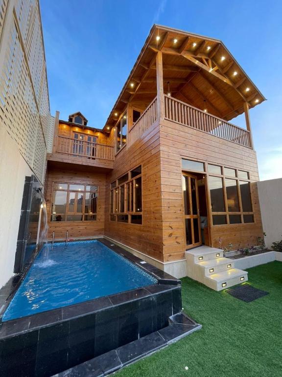a house with a swimming pool in the yard at اكواخ وشاليهات لوزان الريفية 2 in Dahaban