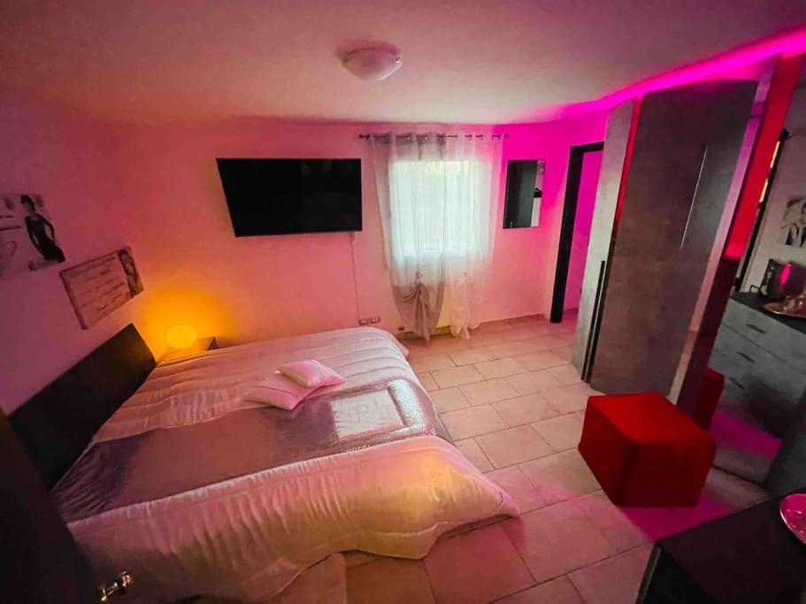 um quarto com uma cama grande e iluminação rosa em Appartamento a Udine con doccia idromassaggio 