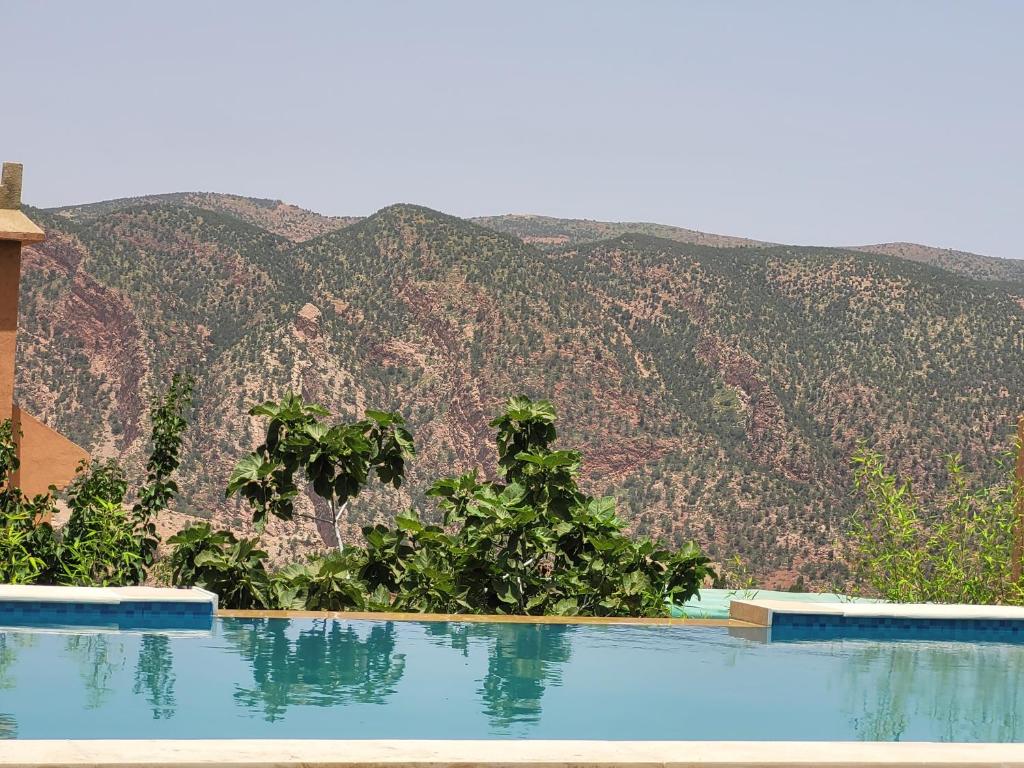 a swimming pool with a mountain in the background at Chambre d'hôtes aya in Ouzoud