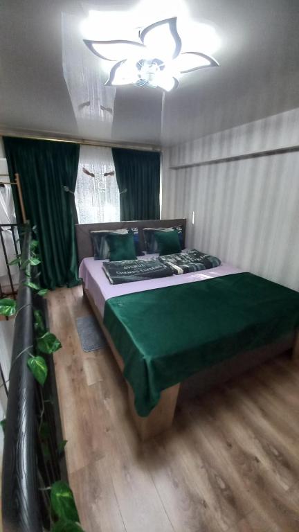 トビリシにあるMarie apartamentのベッドルーム1室(緑のシーツと天井付)