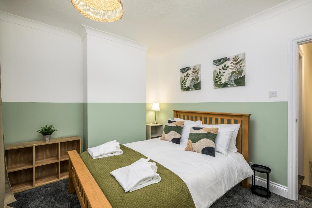 a bedroom with a bed with white sheets and pillows at Vale House By EDEN Accommodation - 2 Bedroom Whole House, Sleeps 4 - NEWLY RENOVATED in Kettering