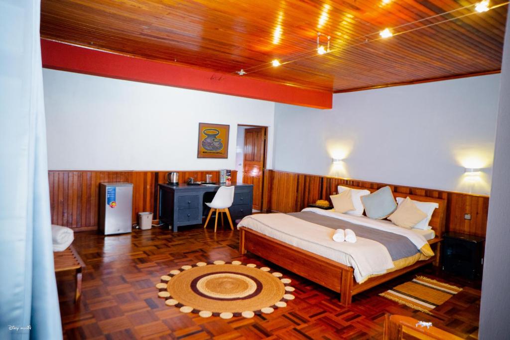 sypialnia z łóżkiem i biurkiem w obiekcie L'anis Etoilé w mieście Antsirabe