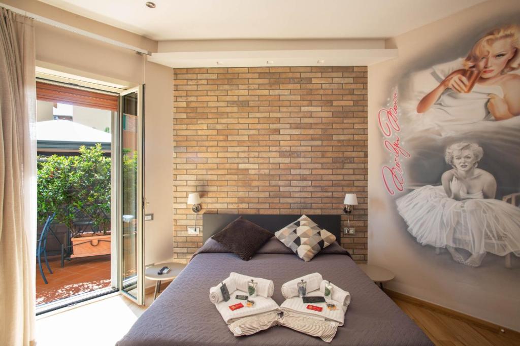 ein Schlafzimmer mit einem Bett und einer Ziegelwand in der Unterkunft Little Rock Guest House in Gaeta