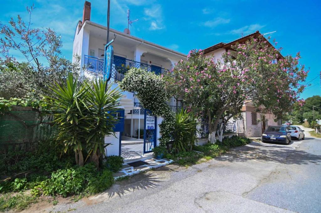 a white house with blue shutters on a street at Villa Stegiovana in Stavros