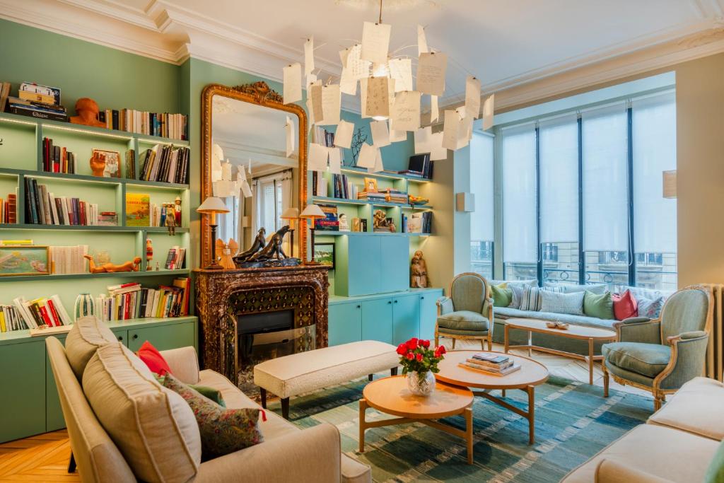 - un salon avec des murs verts et un miroir dans l'établissement Paris Wagram Design Residence, à Paris