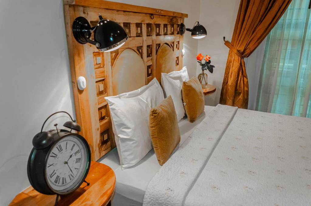1 dormitorio con 1 cama con reloj en Old Town Quito Suites, Heritage Boutique Hotel, Where Every Detail Tells a Story, en Quito