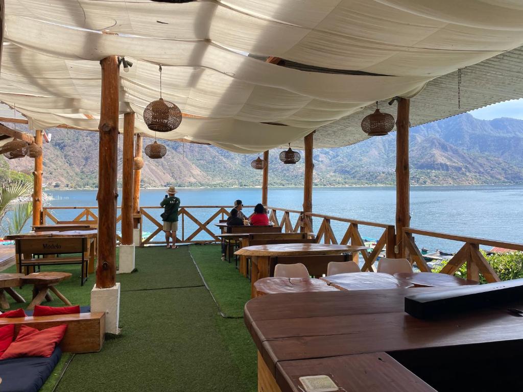 um restaurante com mesas e vista para a água em Casa Blanca - San Pedro em San Pedro La Laguna