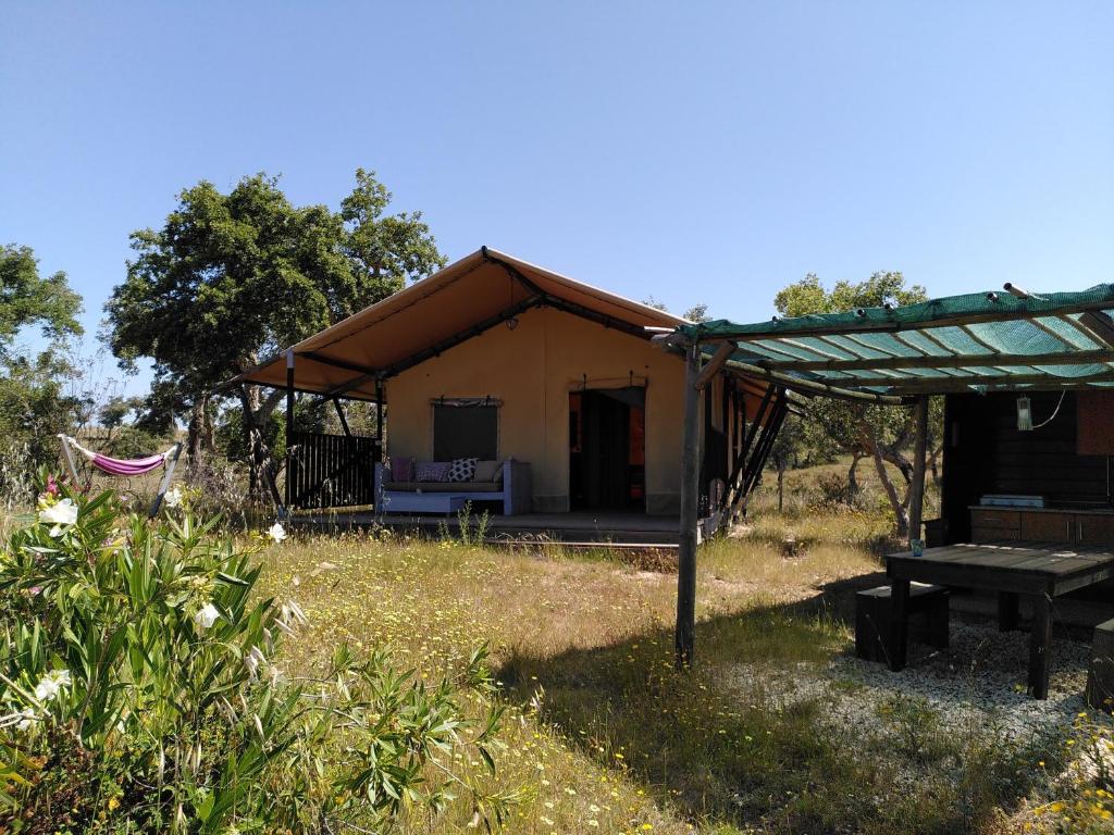 ein Zelt mit einem Picknicktisch auf einem Feld in der Unterkunft Eco Glamping Portugal Nature Lodge in São Luís