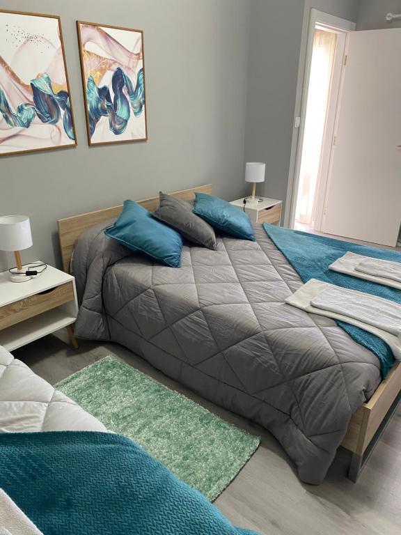 Un dormitorio con una cama con almohadas azules. en Hortênsia's AL, en Praia da Vitória