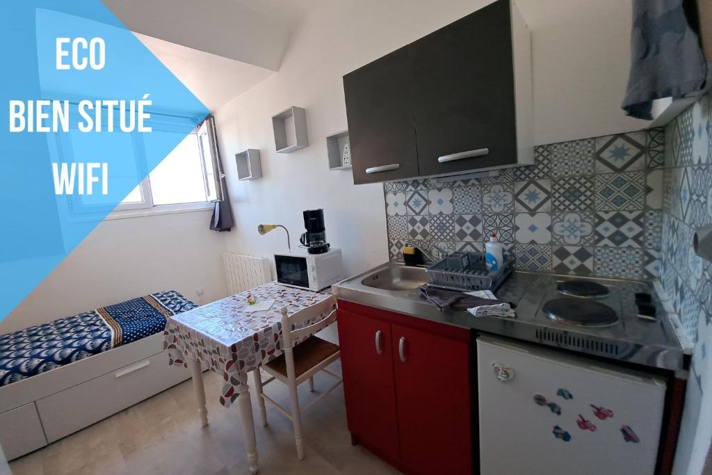 une petite cuisine avec une table et un évier dans l'établissement Studette éco près du phare, à Calais