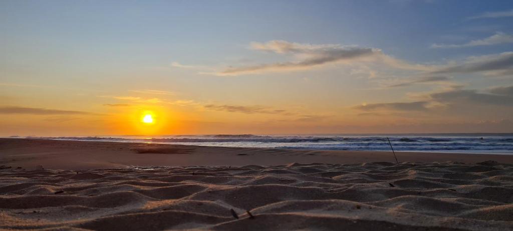 una puesta de sol en una playa con el océano en Ipanema 3, en Margate