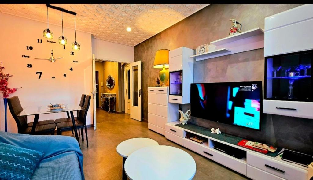 a living room with a large television and a table at piso 3h,5pers,s-c,1b,cocina in Gijón