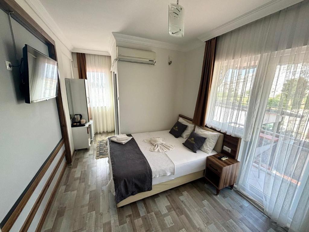 Pamukkale Sahin Boutique Hotel في باموكالي: غرفة نوم بسرير ونافذة كبيرة