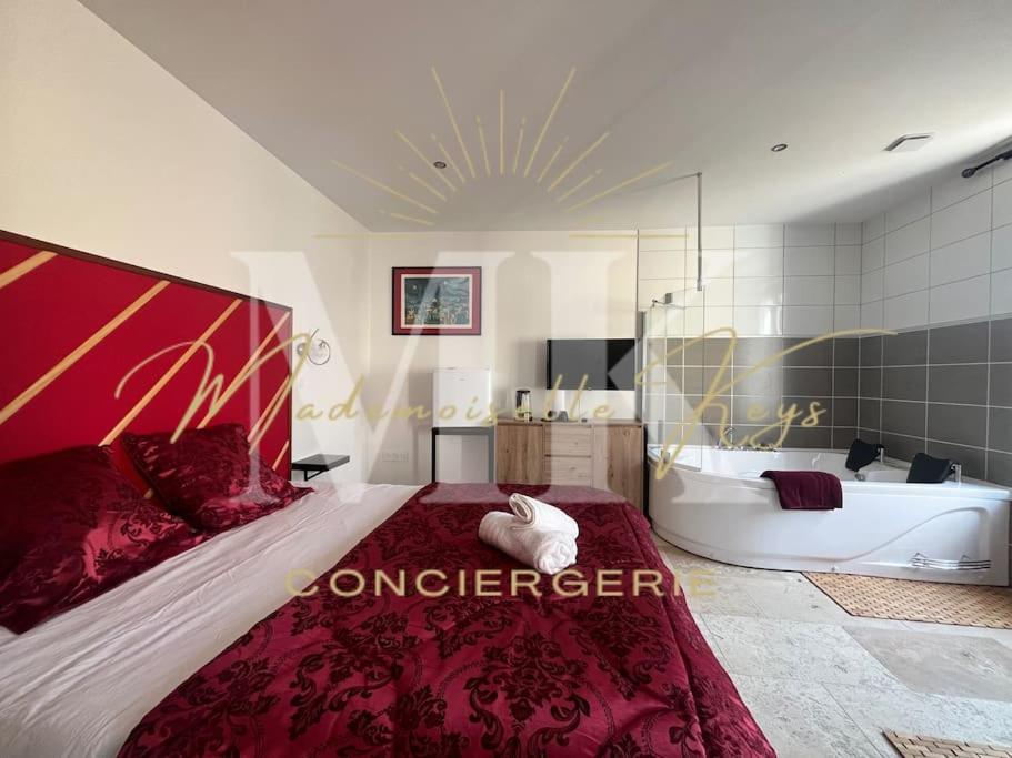 a bedroom with a large bed and a bath tub at La Suite Love de l Écu in Villeneuve-sur-Yonne