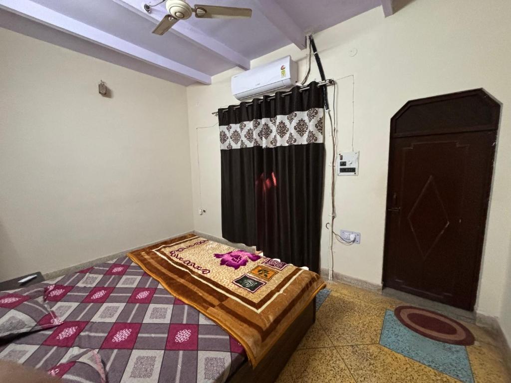 a bedroom with a bed and a black curtain at Rukmani Home Stay in Mathura