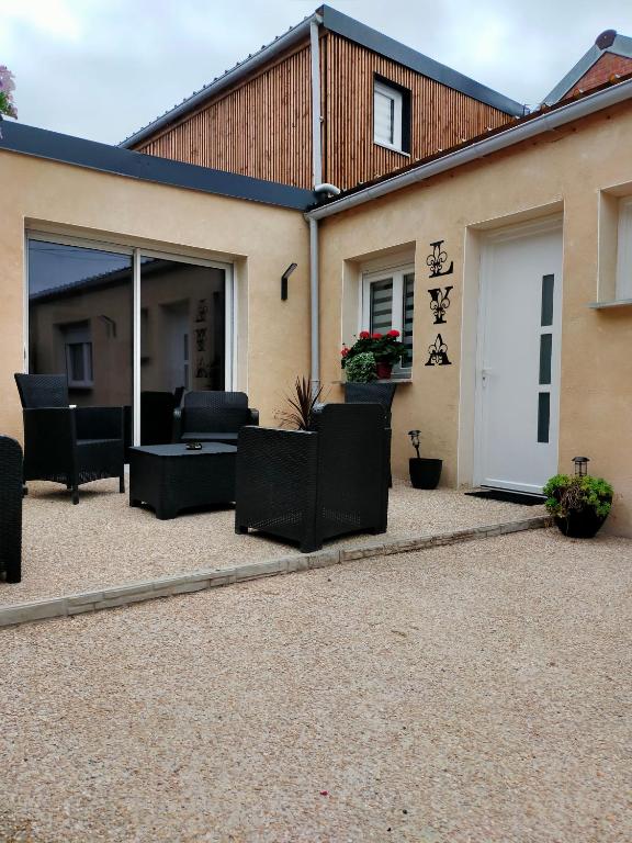 a patio with black furniture in front of a house at La maison de LYA (lyaroom) in Lallaing