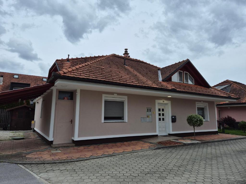 uma pequena casa branca com um telhado vermelho em Oddih v mirnem in zelenem okolju em Škofljica