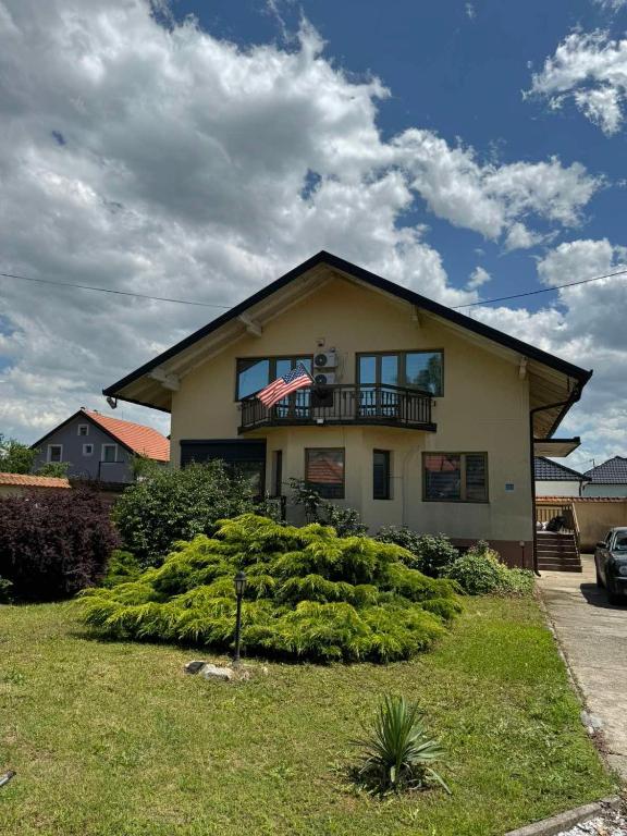 a house with a balcony on top of it at Vila Andrijana in Bijeljina