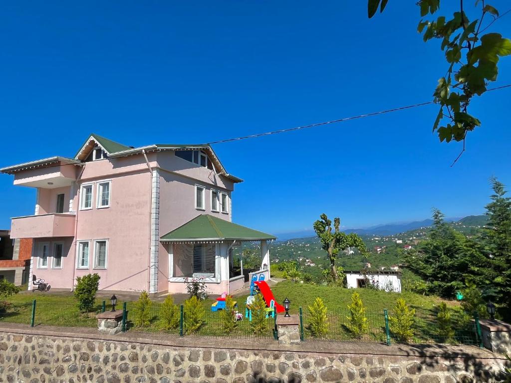 a large pink house on top of a hill at Nature Family House in Arsin