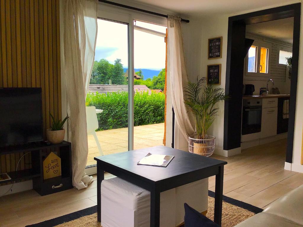 un soggiorno con tavolo e porta scorrevole in vetro di VUE LAC LODGES a Sevrier