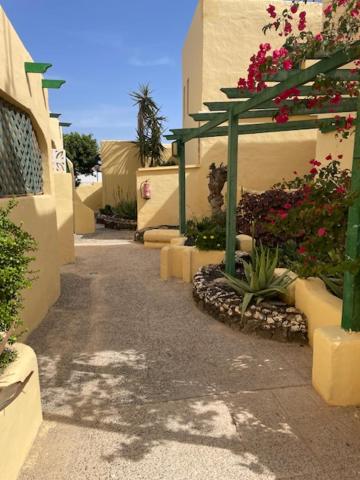 a walkway with flowers on the side of a building at Villa Los Silos in Costa Calma