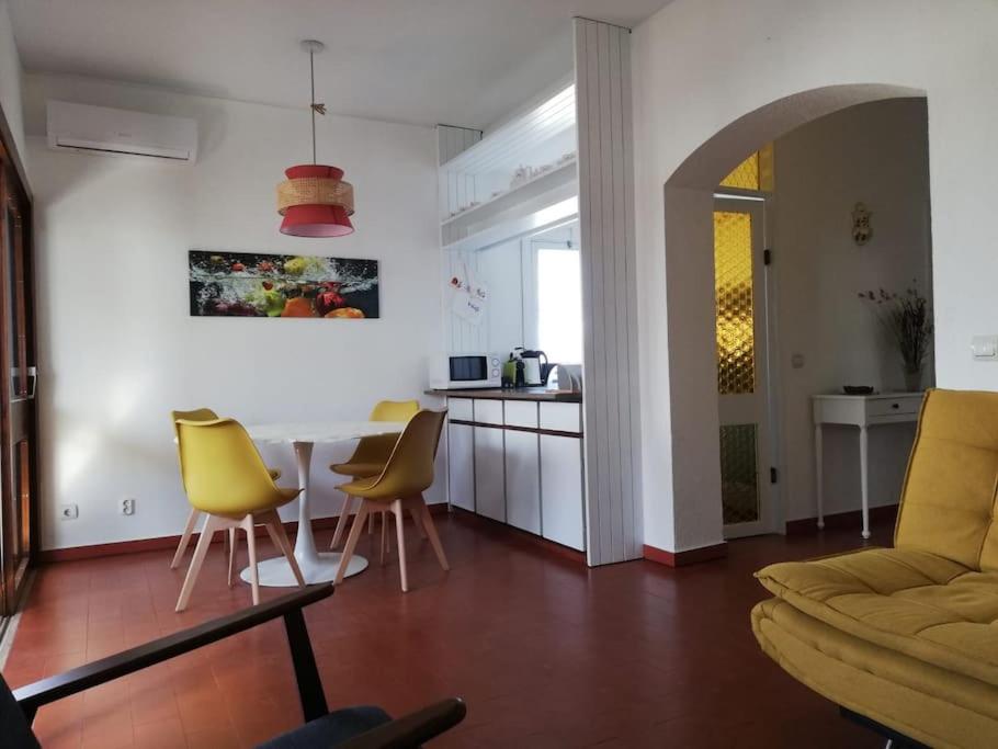 Una sala de estar con una mesa y sillas amarillas. en Four Seasons House, en Monte Gordo