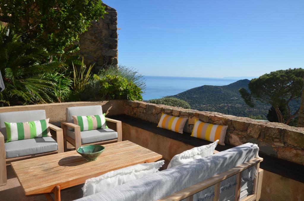 un patio avec une table et des chaises et l'océan dans l'établissement Air-conditioned authentic village house with sea view, terraces and swimming pool, à Monticello