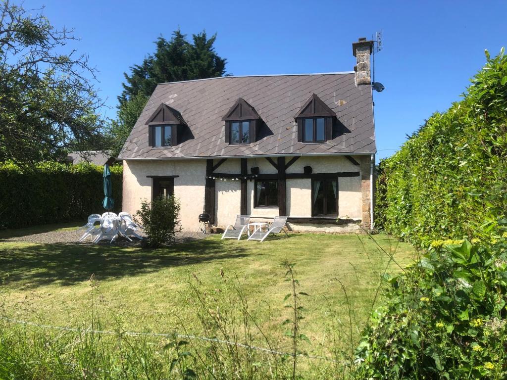 a house with a gray roof on a yard at Daisy Cottage with seasonal Swimming Pool in Le Mesnil-Gilbert